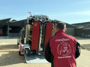 Ein Klauenpfleger der Findeisen Klauenpflege GmbH & Co. KG fährt den hydraulischen Klauenpflegestand HY400RT mit Raupenlaufwerk von einem Anhänger herunter.